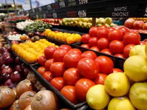 Fresh tomatoes are displayed on a shelf at a market