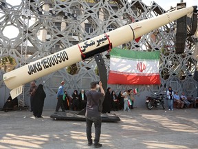 Iranians stand next to a symbol of a Kheibar missile as they take part during a rally in support of the country's supreme leader Mojtaba Khamenei and commemorate Eid al-Ghadir in Tehran on June 4, 2026.