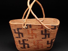 Indigenous basket woven with geometric designs, including swastika shaped motif.
