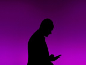 In this file photo taken on February 25, 2019 a visitor uses his phone at the Mobile World Congress (MWC) in Barcelona