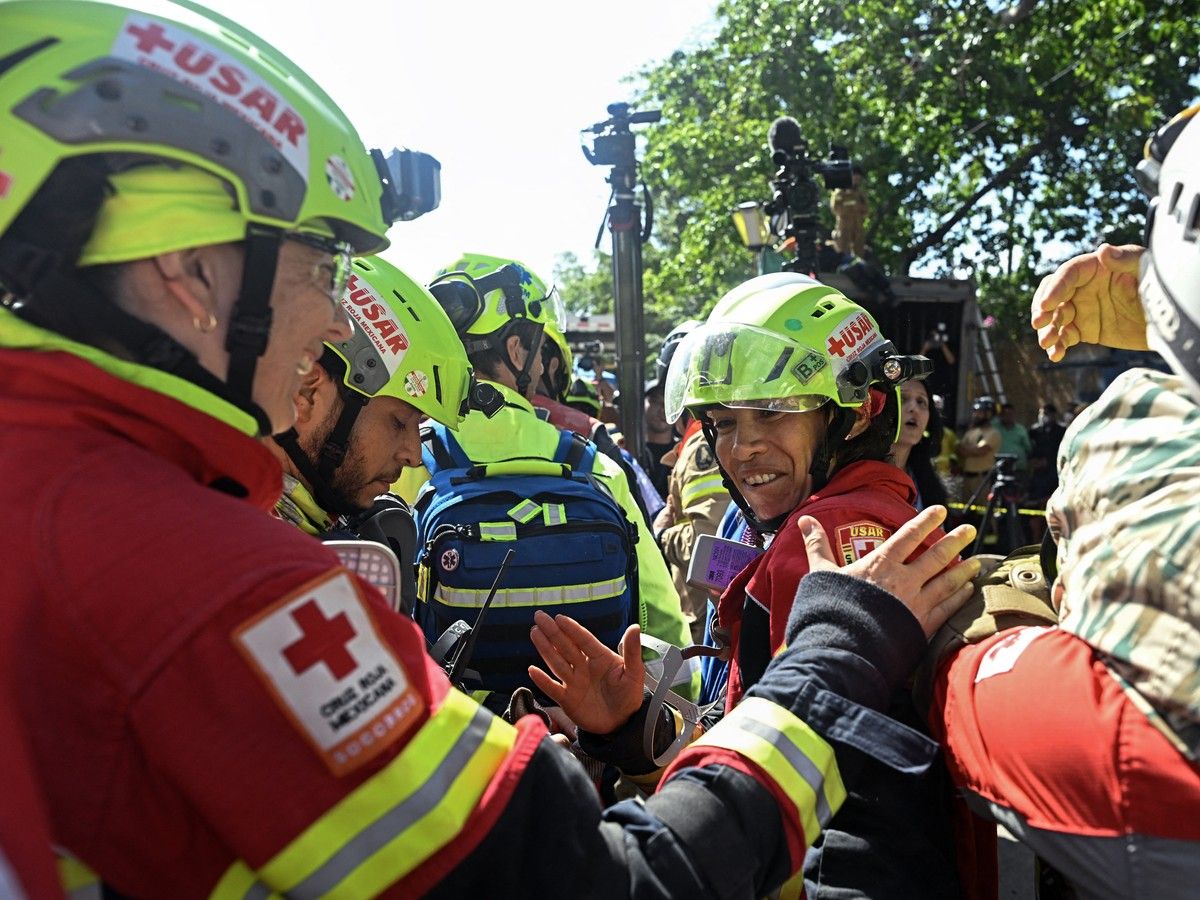  Mexican rescue workers celebrate after loading rescued Hernan Gil onto an ambulance, in Catia La Mar, La Guaira State, Venezuela on July 2, 2026, eight days after twin earthquakes.