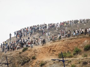 Migrants attempting to cross into Spain's North African enclave of Ceuta gather on a hilltop during clashes with Moroccan security forces near the town of Fnideq, on the Morocco-Spain border, on July 31, 2026.
