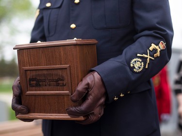 A close up of the urn holding the ashes of the late RCMP Supt. Joe Atherton being carried by a person in uniform.