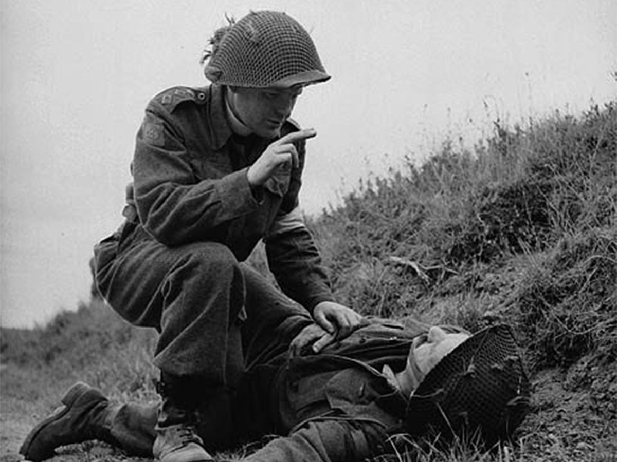 In a photograph from July 15, 1944, Capt. Robert Seaborn, Chaplain of the 1st Battalion, the Canadian Scottish Regiment, gives absolution to an unidentified soldier of the 3rd Canadian Infantry Division near Caen, France. Retired military chaplain Rav Sean Gorman writes that the Sailors and Marines he ministered to called on him for more than 
