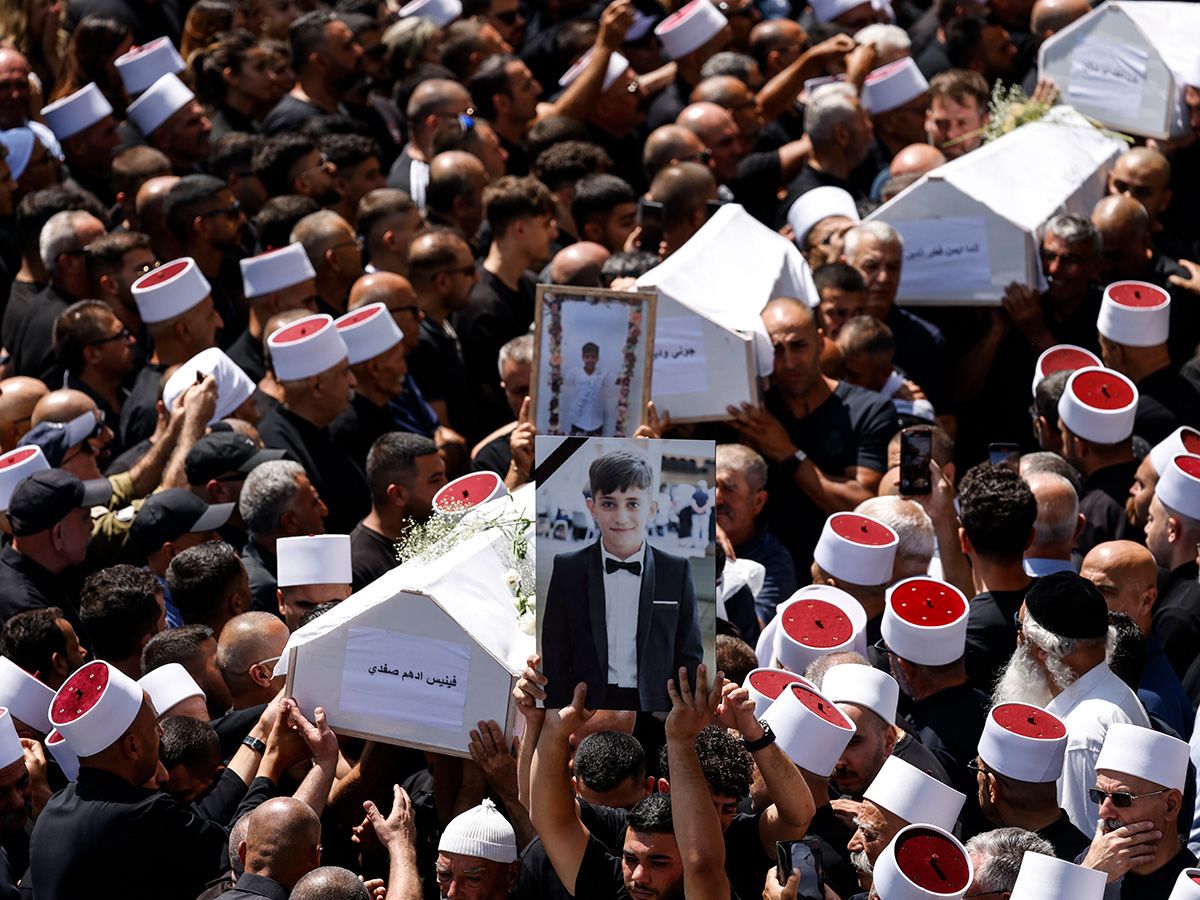 Coffins being carried at a public funeral.