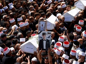 Coffins being carried at a public funeral.