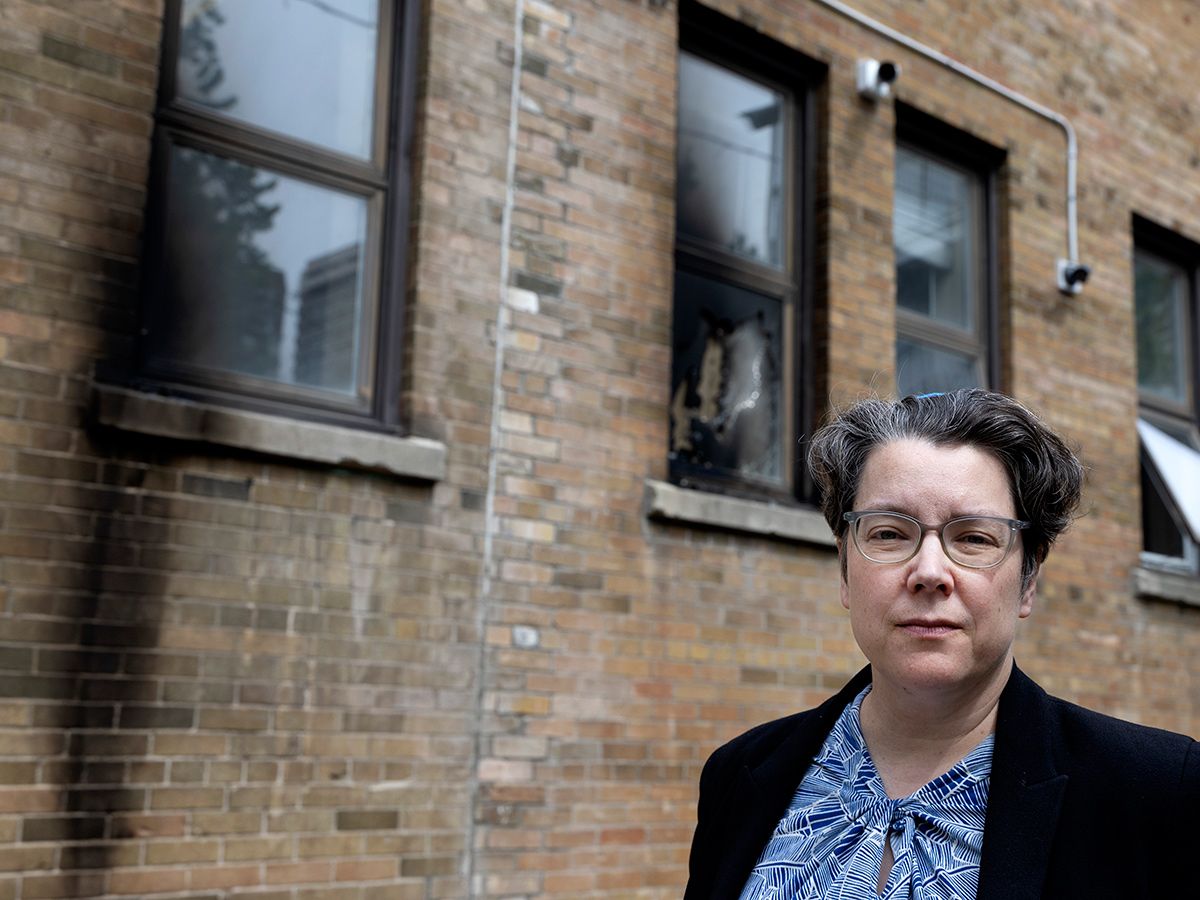Rabbi Lisa Grushcow stands near a burned out window after an overnight arson attack at Temple Emanu-El-Beth Sholom in Montreal, on June 5, 2026.