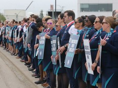 WestJet Flight attendants stands with signs