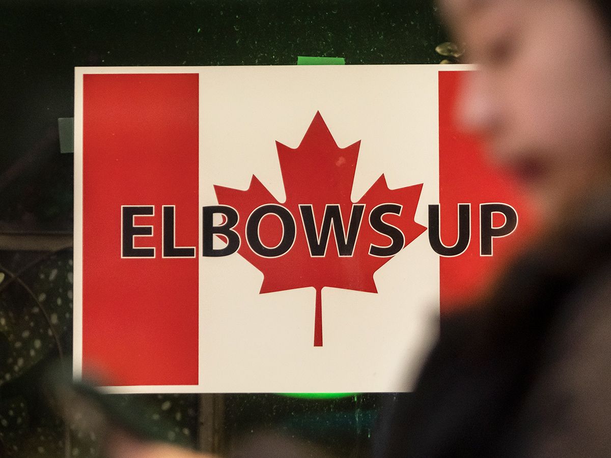  A woman walks past an “Elbows Up” sign in Toronto on April 11, 2025.