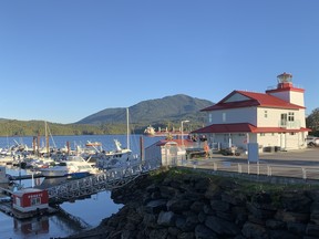 A harbour in Prince Rupert, British Columbia with a green hill in the background under a blue sky.