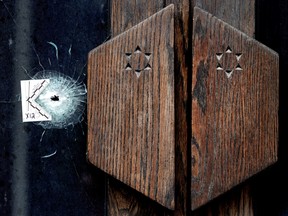 ullet holes mark the front doors and windows of Jewish Temple Emanu-El in Toronto, Tuesday March 3, 2026.