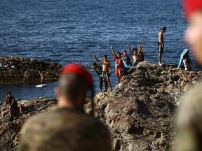 Infantry forces watch a group of migrants near the border post of the Spanish enclave of Ceuta