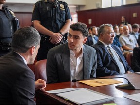 Luigi Mangioni sat in a courtroom talking to a man sat next to him.