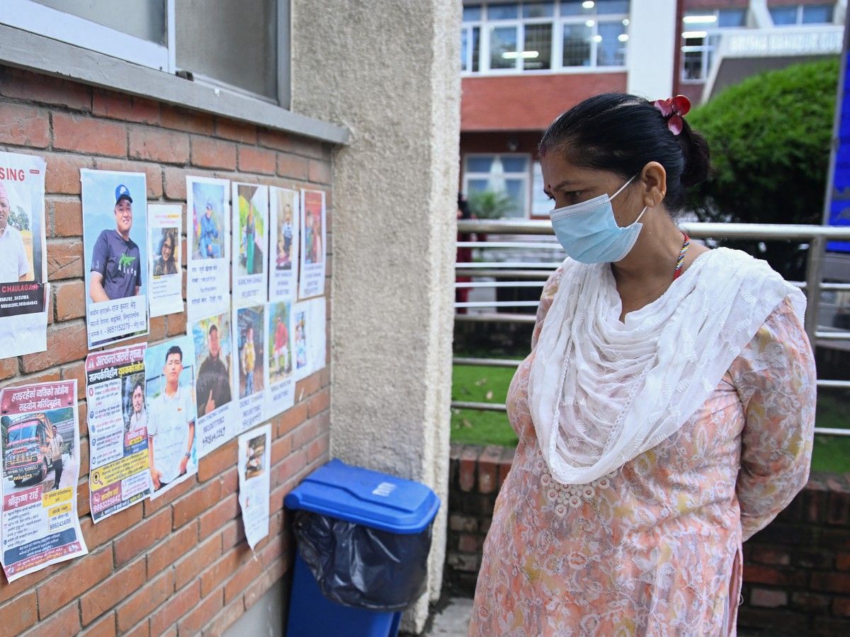 A woman looks at photographs of the missing