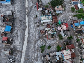 An aerial view shows debris and mud covering an area following flash floods