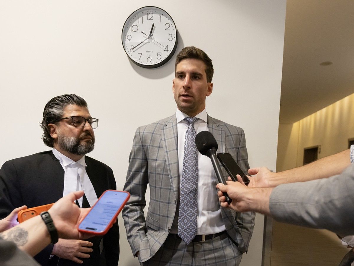 Toronto Maple Leaf centre John Tavares, right, speaks to media at a Toronto court during a break in his ongoing tax case with his lawyer Justin Kutyan, left, on Aug. 18.
