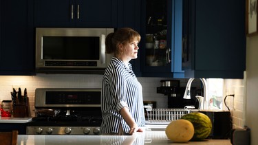 Former police detective Julie Meier, stands in her kitchen.