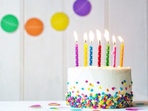 Birthday cake on a table with 7 colourful candles.