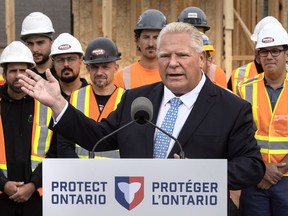Doug Ford speaking at podium, trades workers behind him
