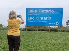 Woman taking photo of Lake Ontario billboard