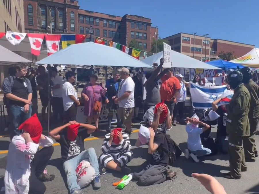 A screenshot from a Facebook video shows a demonstration in front of a booth representing Israel at the International Culturefest Aug. 2 in Saint John. COURTESY OF ASK SAINT JOHN/FACEBOOK A screenshot from a Facebook video shows a demonstration in front of a booth representing Israel at the International Culturefest Aug. 2 in Saint John. COURTESY OF ASK SAINT JOHN/FACEBOOK