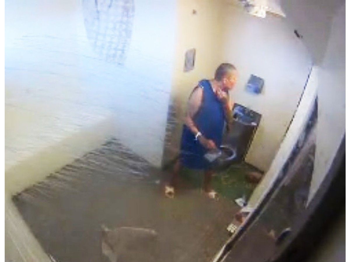 Man in smock in prison isolation cell