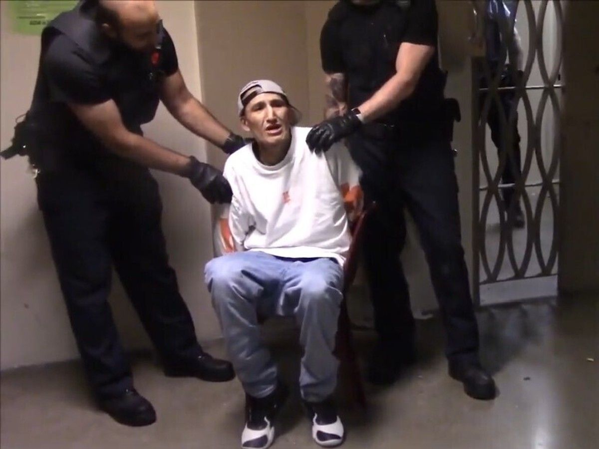 Prison guards handling a handcuffed man