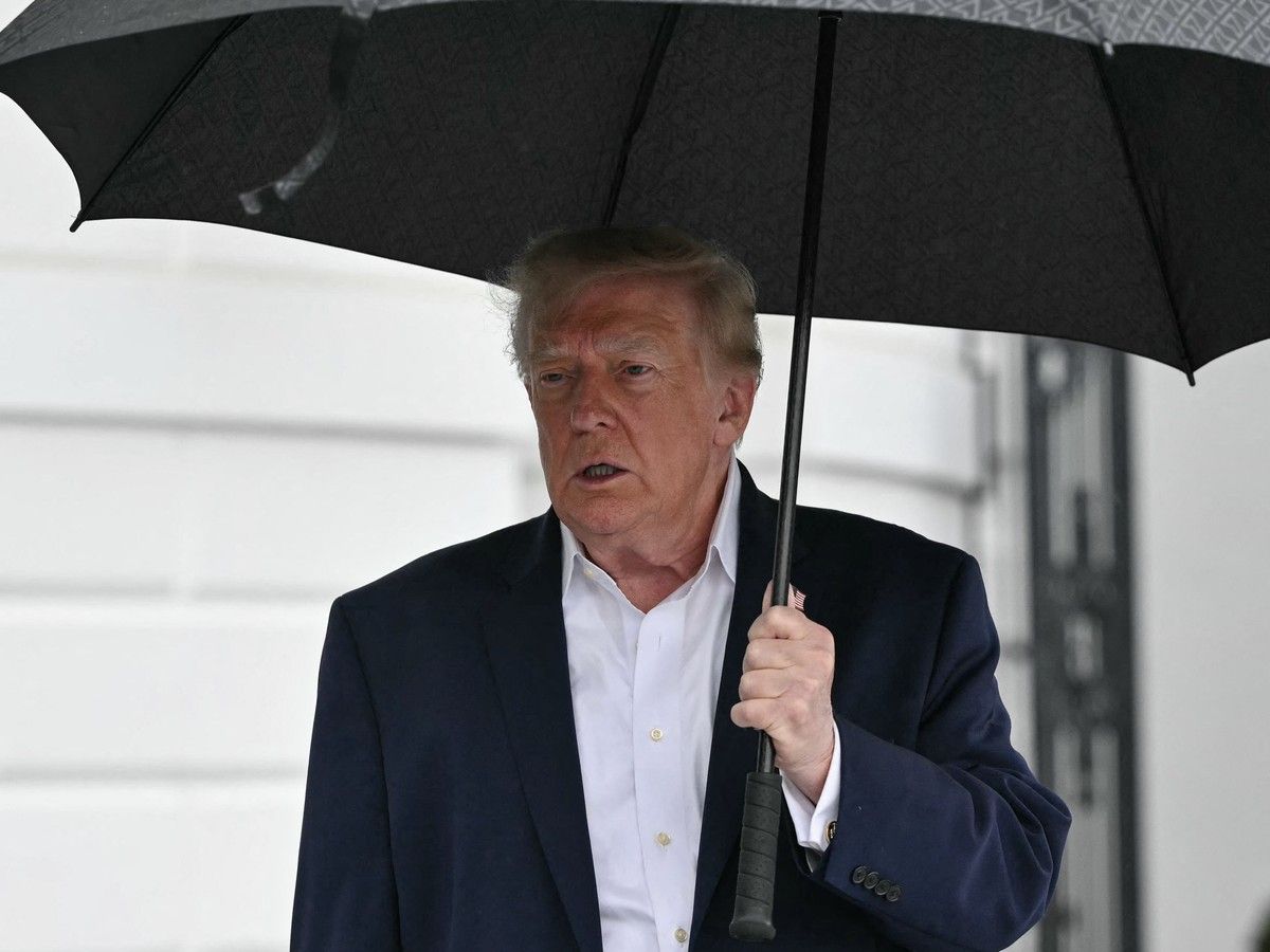 Trump holding an umbrella outside White House