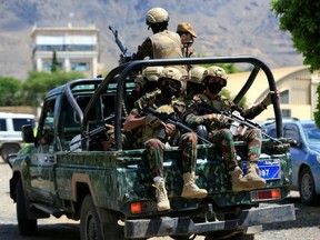 Yemen's Houthi armed forces patrol as Yemeni prisoners loyal to the Houthi authorities arrive in the capital Sanaa on September 12.