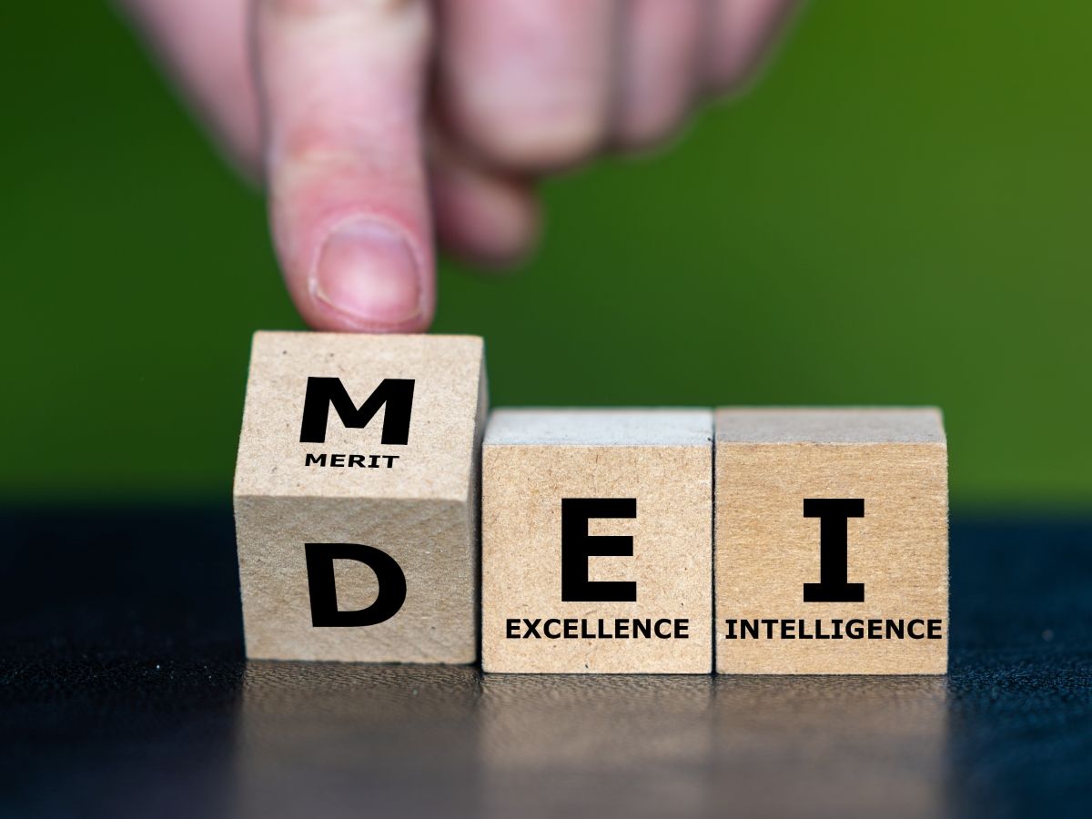 Hand turns cube and changes the expression DEI (diversity, equity and inclusion) to MEI (merit, excellence and intelligence) getty