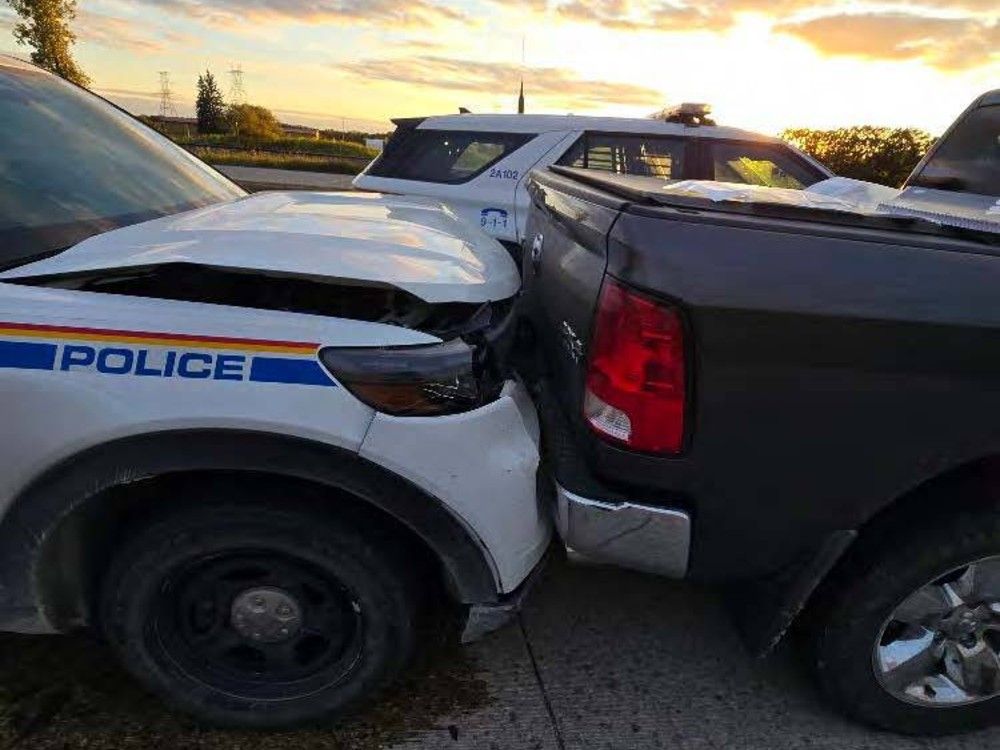 Damaged RCMP vehicle behind truck