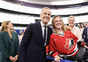 Mark Carney (left) smiles next to Terry Reintke, who is wearing a Team Canada jersey.