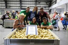 Tyler Heppell, left, poses for a photo with several Ugly Potato Day volunteers, an adjudicator from Guinness World Records, and Evan Ehlers from Sharing Excess.