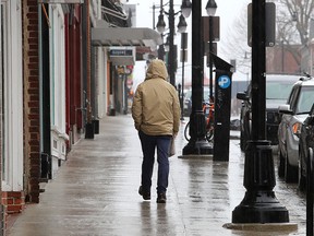 A lone man on a sidewalk.