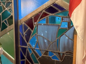 Bullet holes in a stained glass window.