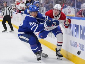 William Nylander #88 of the Toronto Maple Leafs battles for the puck with Lane Hutson #48 of the Montréal Canadiens