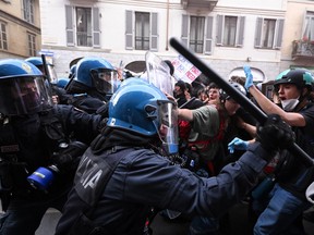 Police in riot gear clash with protestors.