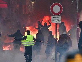 Protestors stand in front of a fire during a protest in France
