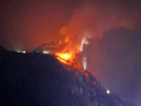 A building on top of a hill on fire.