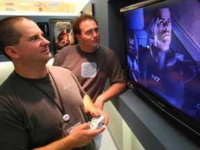 In this photo from 2008, BioWare Head writer Drew Karpyshyn (left) and Mike Laidlaw show off a Mass Effect game on screen.