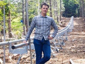Martin Kejval of Nova Scotia's Cape Smokey stands beside mountain track under construction.