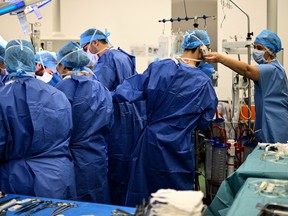 Doctor in a crowded operating room talking on the phone.