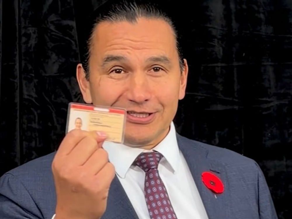 Wab Kinew holding an ID card