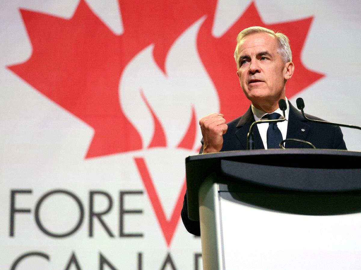 Mark Carney stands behind a lectern with a Forever Canadian logo behind him.
