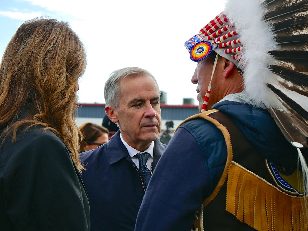 From left: Alberta Premier Danielle Smith, Prime Minister Mark Carney and Fort McKay First Nation Chief Raymond Powder speak following the federal government's announcement to list the Pacific Link pipeline as a project of national interest, in Fort McMurray, Alta., on Oct. 1, 2026.