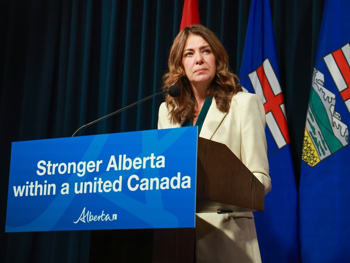 Danielle Smith stands behind a lectern.