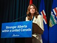 Danielle Smith stands behind a lectern.