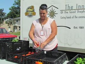 Judy L'Heureux, coordinator of the Inn of the Good Shepherd's seasonal mobile markets, bags tomatoes during a stop last summer in Sarnia. The markets has begun making weekly stops at 14 locations with free fresh produce for those in need. The annual program is expected to run through the fall. (Paul Morden/Sarnia Observer/Postmedia Network)