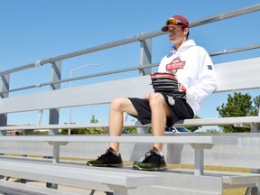 St. Thomas's Brendan Johnston, a standout pitcher on the AAA U18 London Badgers, sits on the bleachers near Cardinal Field. This school year Johnston will go to North Dakota to play ball for a college team, the second St. Thomas baseball player to win a U.S. scholarship in the last year. (Louis Pin/Times-Journal)