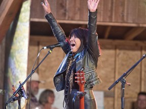 Buffy Sainte-Marie high salutes the crowd as she performs at the Canmore Folk Music Festival in Centennial Park on Monday, August 6, 2018.